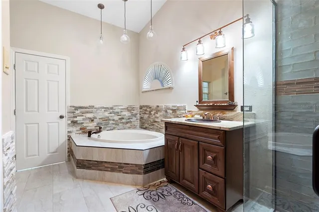 a bathroom with a double vanity sink a mirror and a bathtub