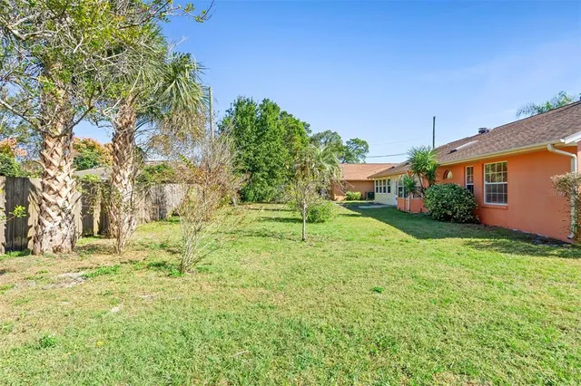 a backyard of a house with plants and large trees