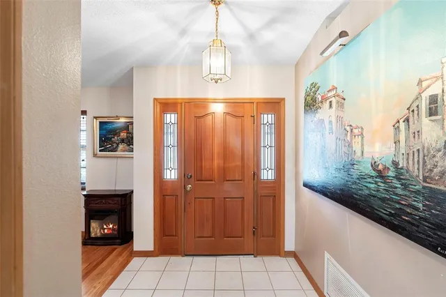 a view of a hallway with wooden floor and a chandelier