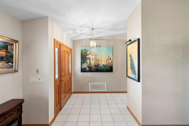 a view of a hallway with a window and chandelier