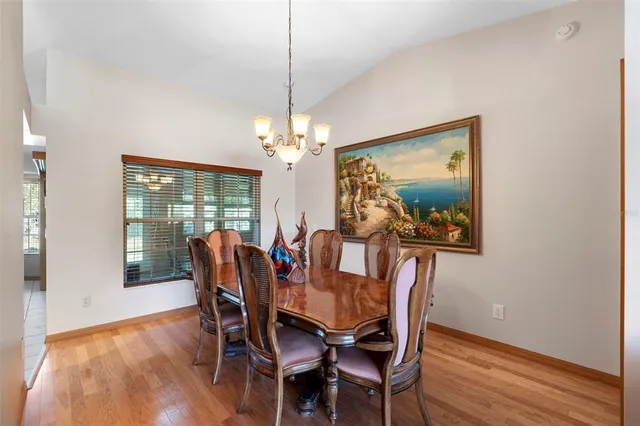 a dining room with furniture a chandelier and wooden floor