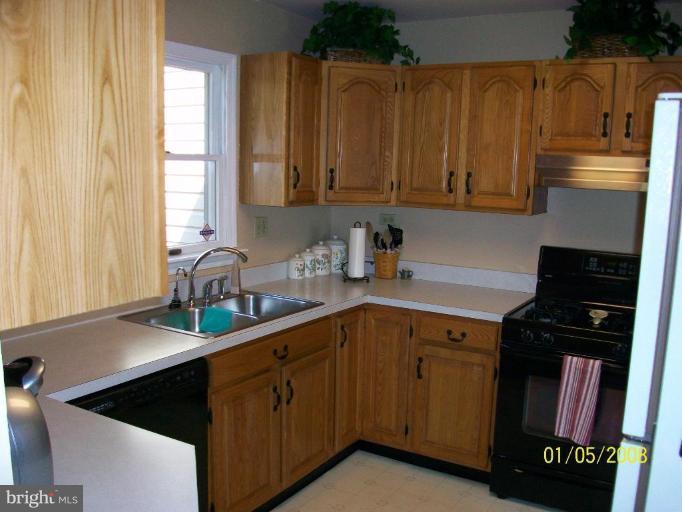 1202 Robin Court Halethorpe, MD 21227 - Photo 11 of 18 a kitchen with granite countertop a sink dishwasher stove and cabinets