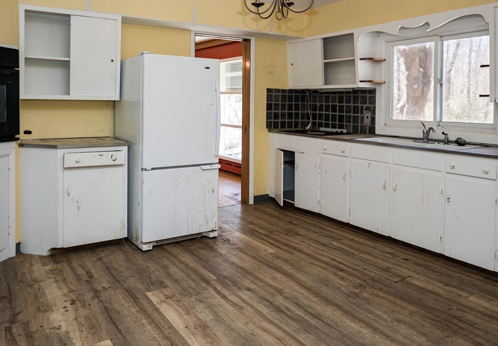 252 Thompson Road Webster, MA 01570 - Photo 21 of 39 a kitchen with a refrigerator a stove and white cabinets