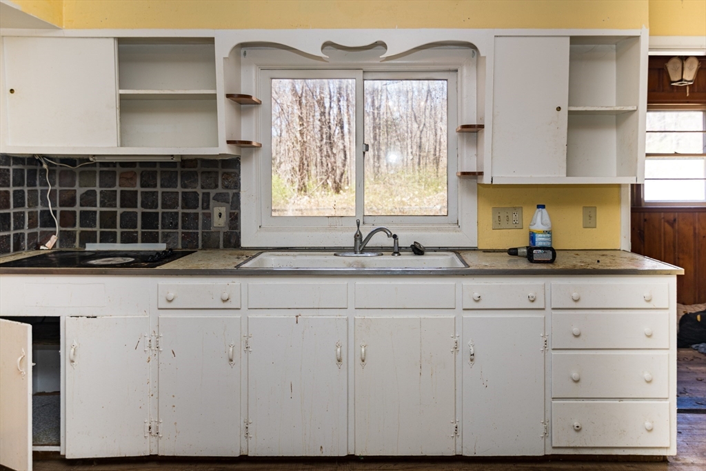 252 Thompson Road Webster, MA 01570 - Photo 23 of 39 a kitchen with granite countertop white cabinets and sink