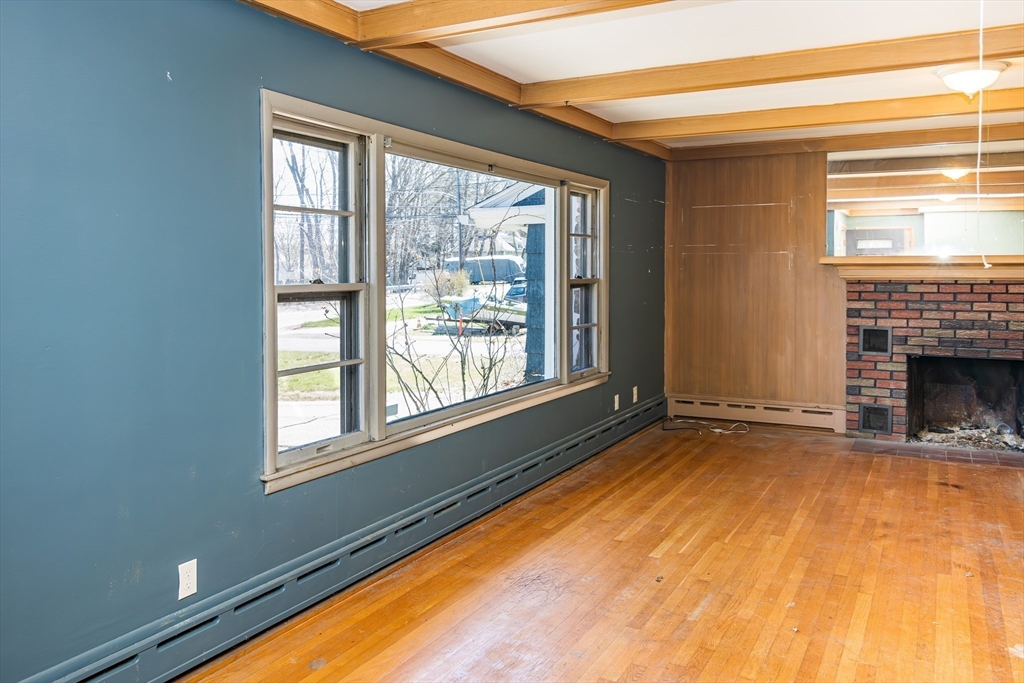 252 Thompson Road Webster, MA 01570 - Photo 9 of 39 a view of an empty room with a fireplace and a window