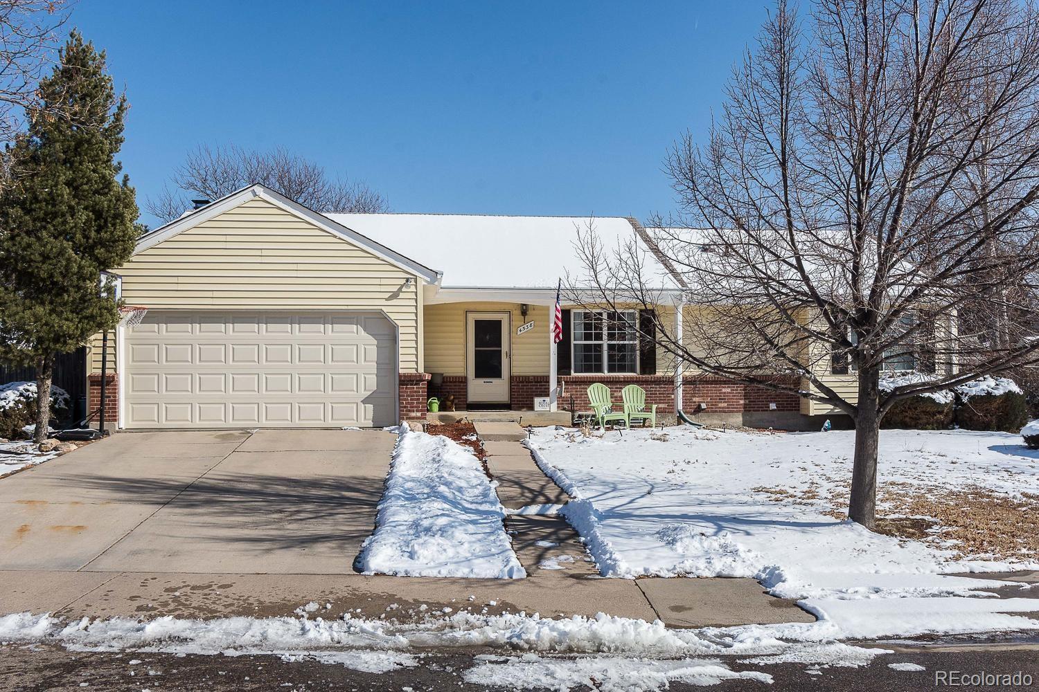 a front view of a house with a yard covered in snow