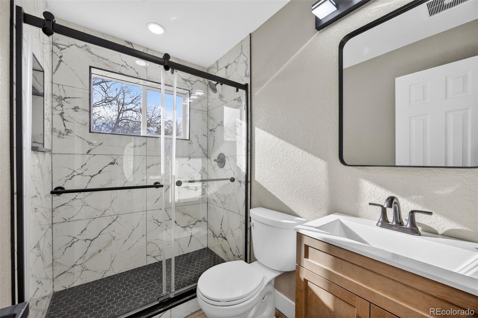 368 Emery Road Northglenn, CO 80233 - Photo 11 of 28 a white toilet sitting next to a bathroom sink