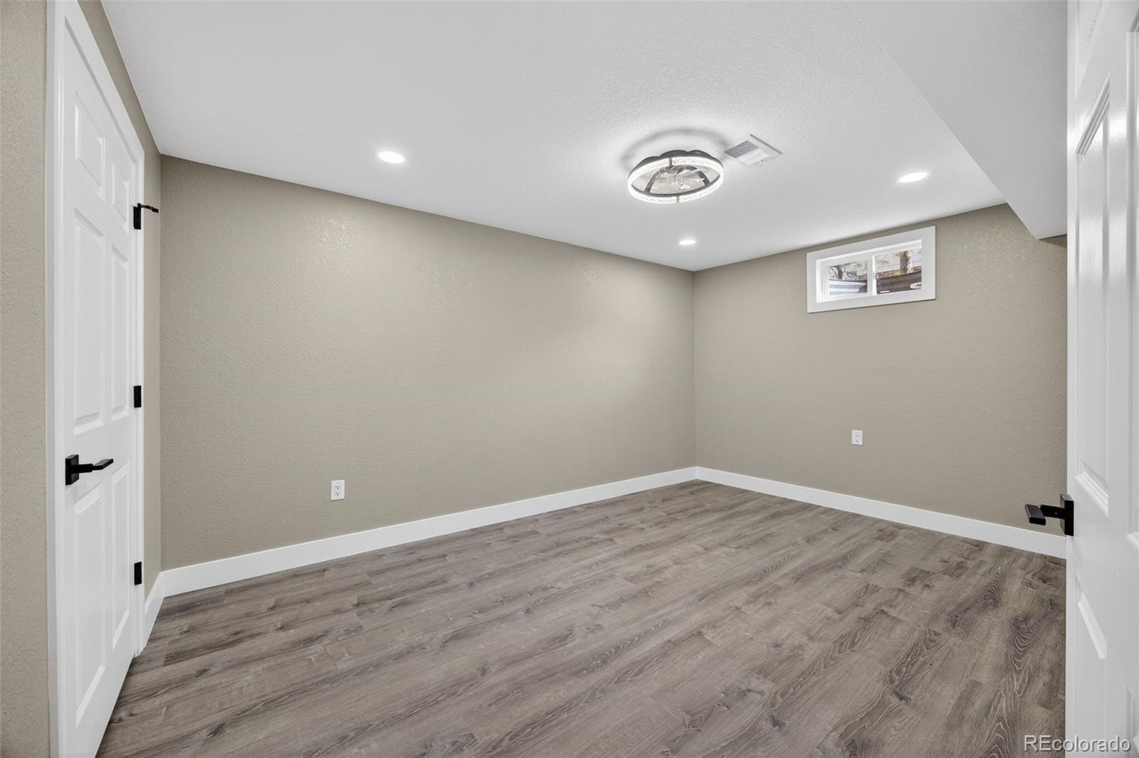 368 Emery Road Northglenn, CO 80233 - Photo 17 of 28 an empty room with wooden floor and entrance