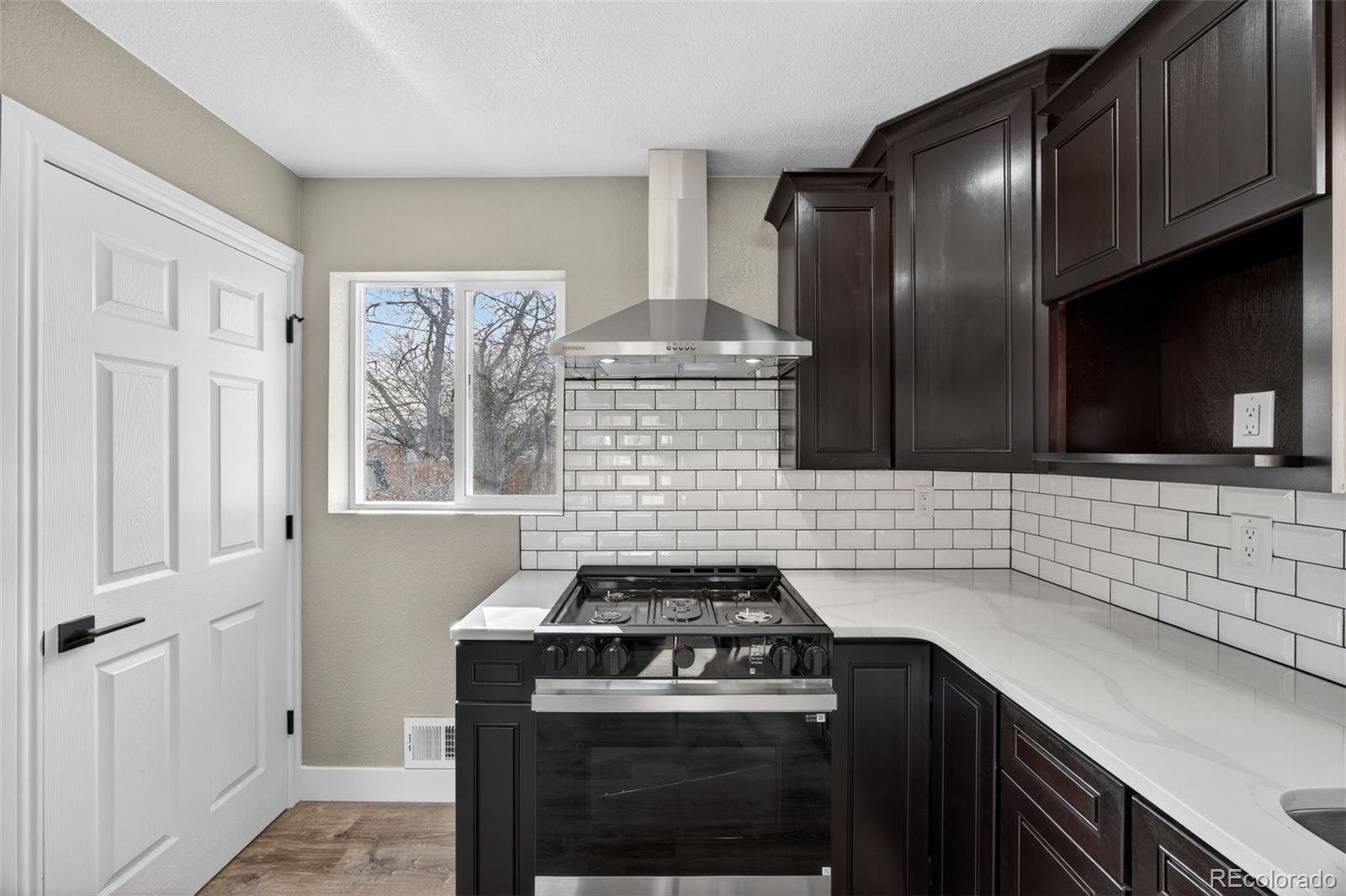 368 Emery Road Northglenn, CO 80233 - Photo 6 of 28 a kitchen with granite countertop a stove sink and cabinets