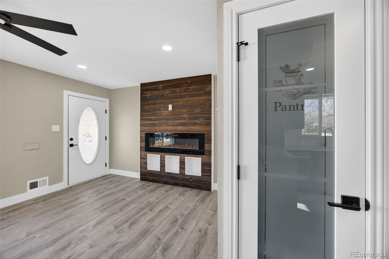 368 Emery Road Northglenn, CO 80233 - Photo 7 of 28 a view of an empty room with wooden floor and a window