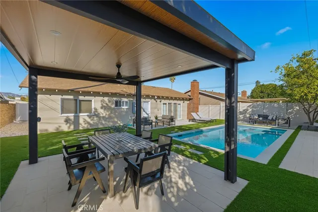a view of a patio with table and chairs under an umbrella
