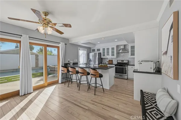 a kitchen with stainless steel appliances kitchen island granite countertop a stove a sink a refrigerator and chairs