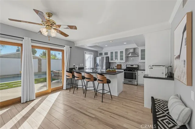 a kitchen with stainless steel appliances kitchen island granite countertop a stove a sink a refrigerator and chairs