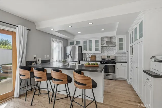 a kitchen with stainless steel appliances granite countertop a table and chairs in it