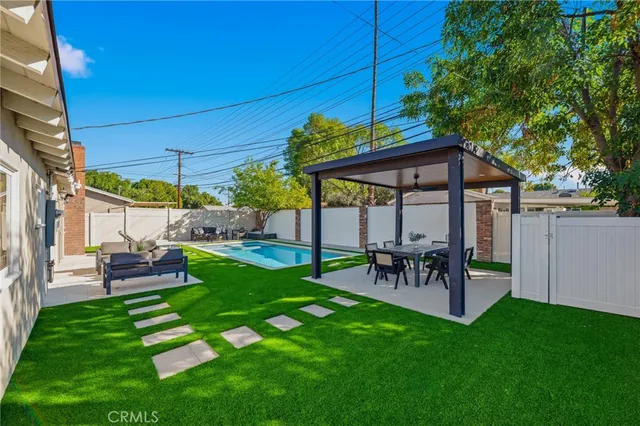 a view of a backyard with table and chairs under an umbrella