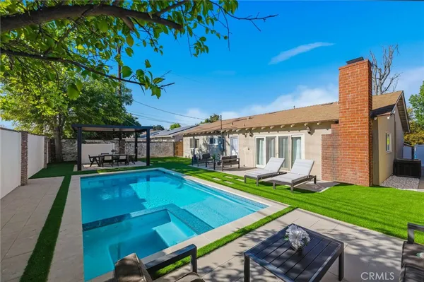 a view of a house with pool and a yard