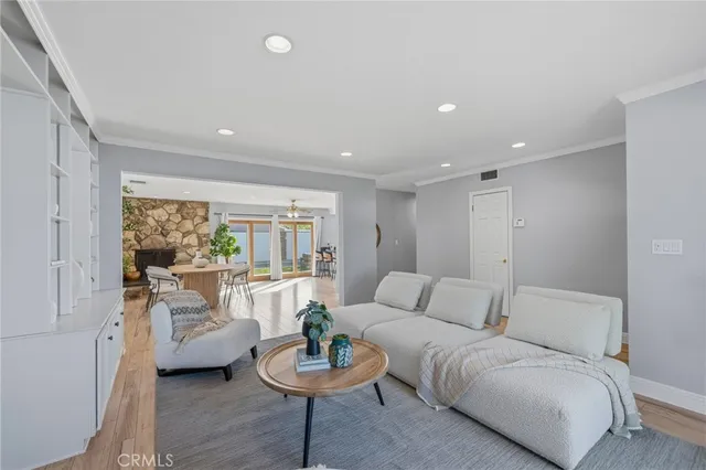 a living room with furniture a chandelier and a dining table with wooden floor