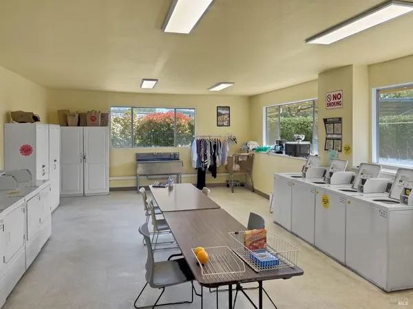 a living room with furniture a flat screen tv and a refrigerator