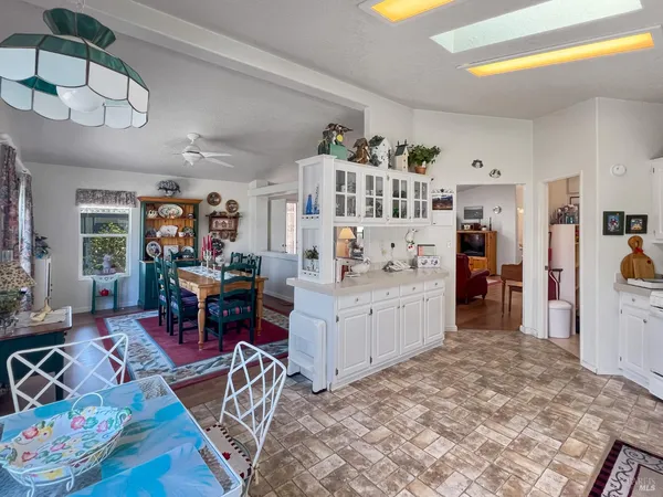 a living room with furniture and a dining table with kitchen appliances