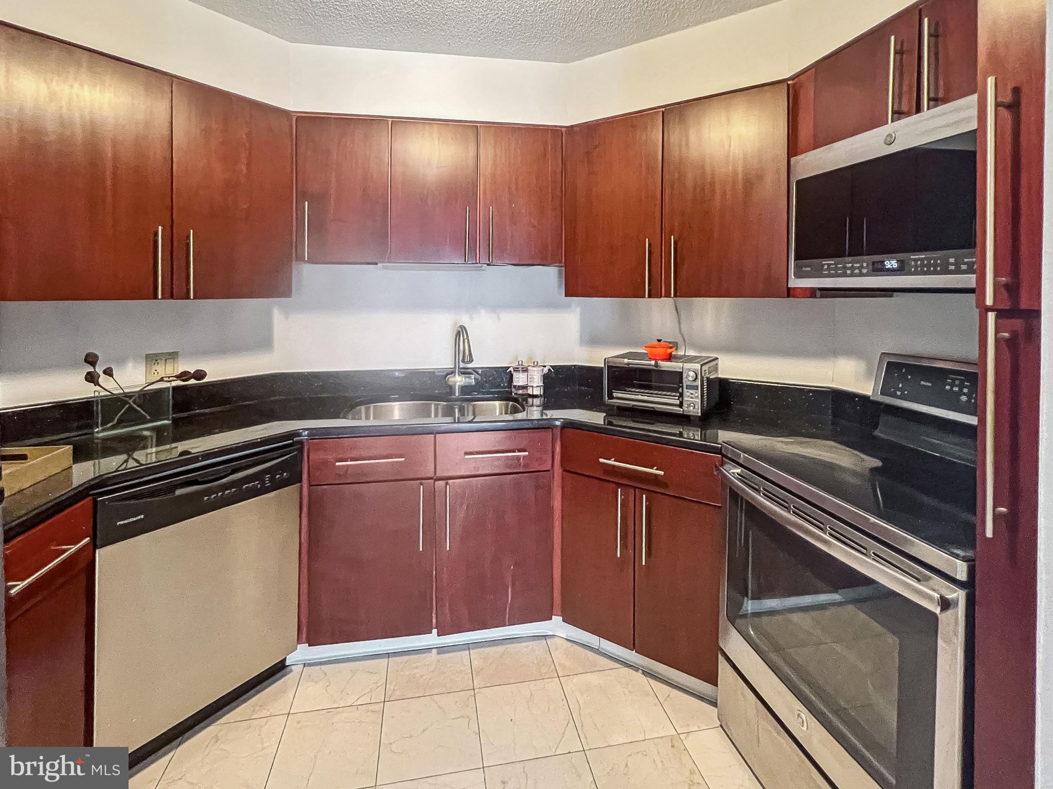 2020 Walnut Street, Unit 29K Philadelphia, PA 19103 - Photo 4 of 20 a kitchen with stainless steel appliances granite countertop a sink stove and microwave
