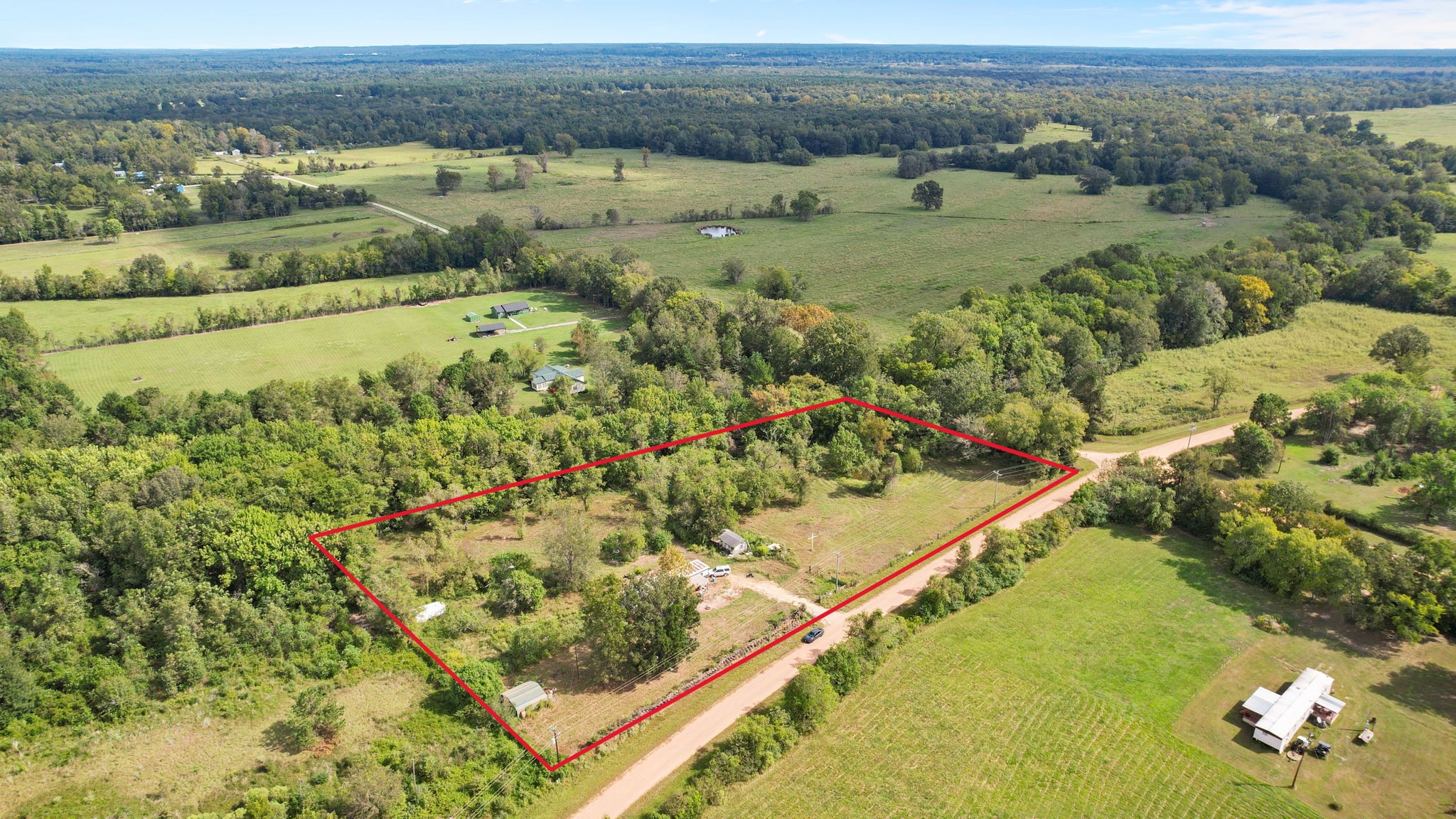 451 Langham Road Shepherd, TX 77371 - Photo 1 of 20 Ready for personal touches, this unrestricted 3+ acres property with outbuilding and a pond.