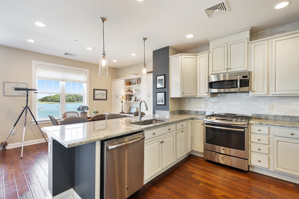 151 HMS Halsted Drive, Unit 151 Hingham, MA 02043 - Photo 21 of 41 a kitchen with stainless steel appliances granite countertop a sink a stove and a wooden floors