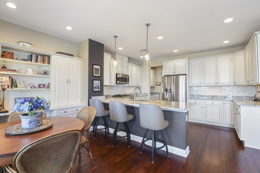 151 HMS Halsted Drive, Unit 151 Hingham, MA 02043 - Photo 22 of 41 a kitchen with stainless steel appliances granite countertop a dining table chairs stove refrigerator and cabinets