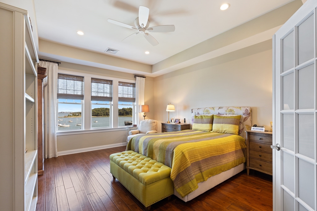 151 HMS Halsted Drive, Unit 151 Hingham, MA 02043 - Photo 27 of 41 a bedroom with a bed couch and a large window with wooden floor