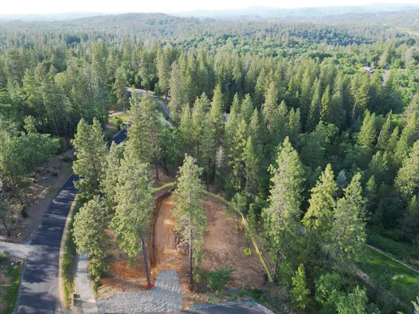 an aerial view of a house with yard and green space