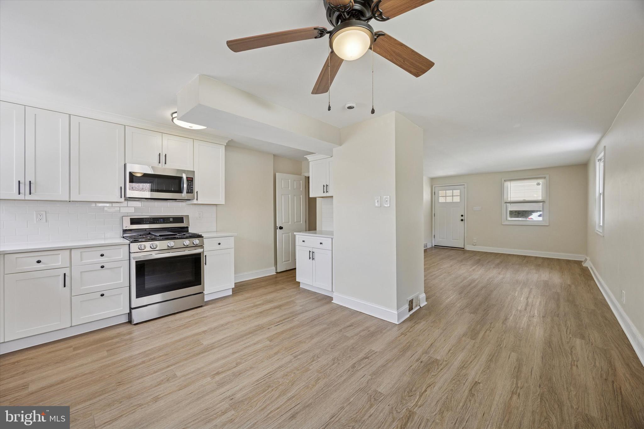 723 Bennington Road Folcroft, PA 19032 - Photo 11 of 25 a kitchen with granite countertop a stove cabinets and wooden floor
