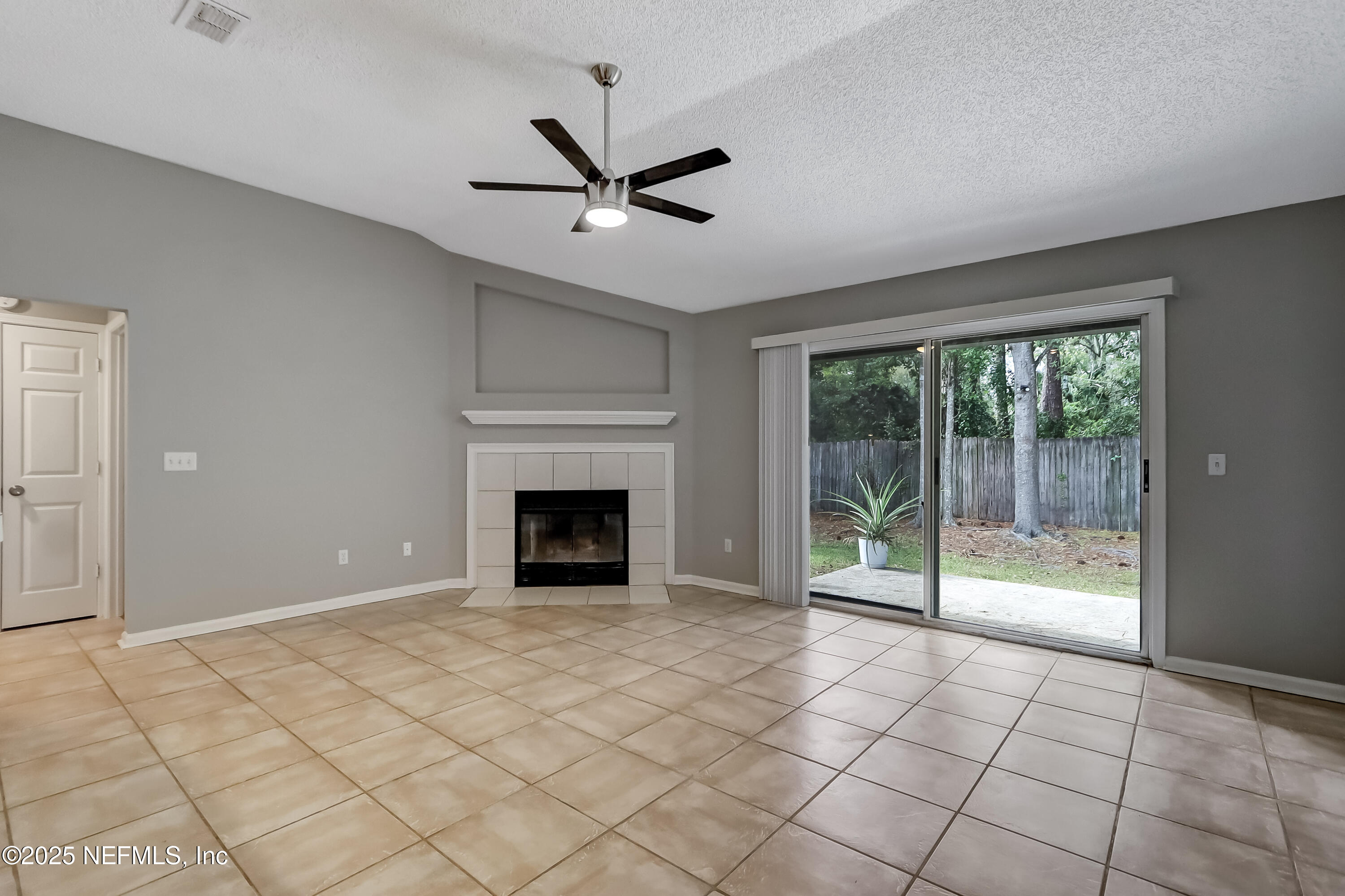 9642 Pritmore Road East Jacksonville, FL 32257 - Photo 17 of 47 a view of an empty room with glass door and a chandelier fan