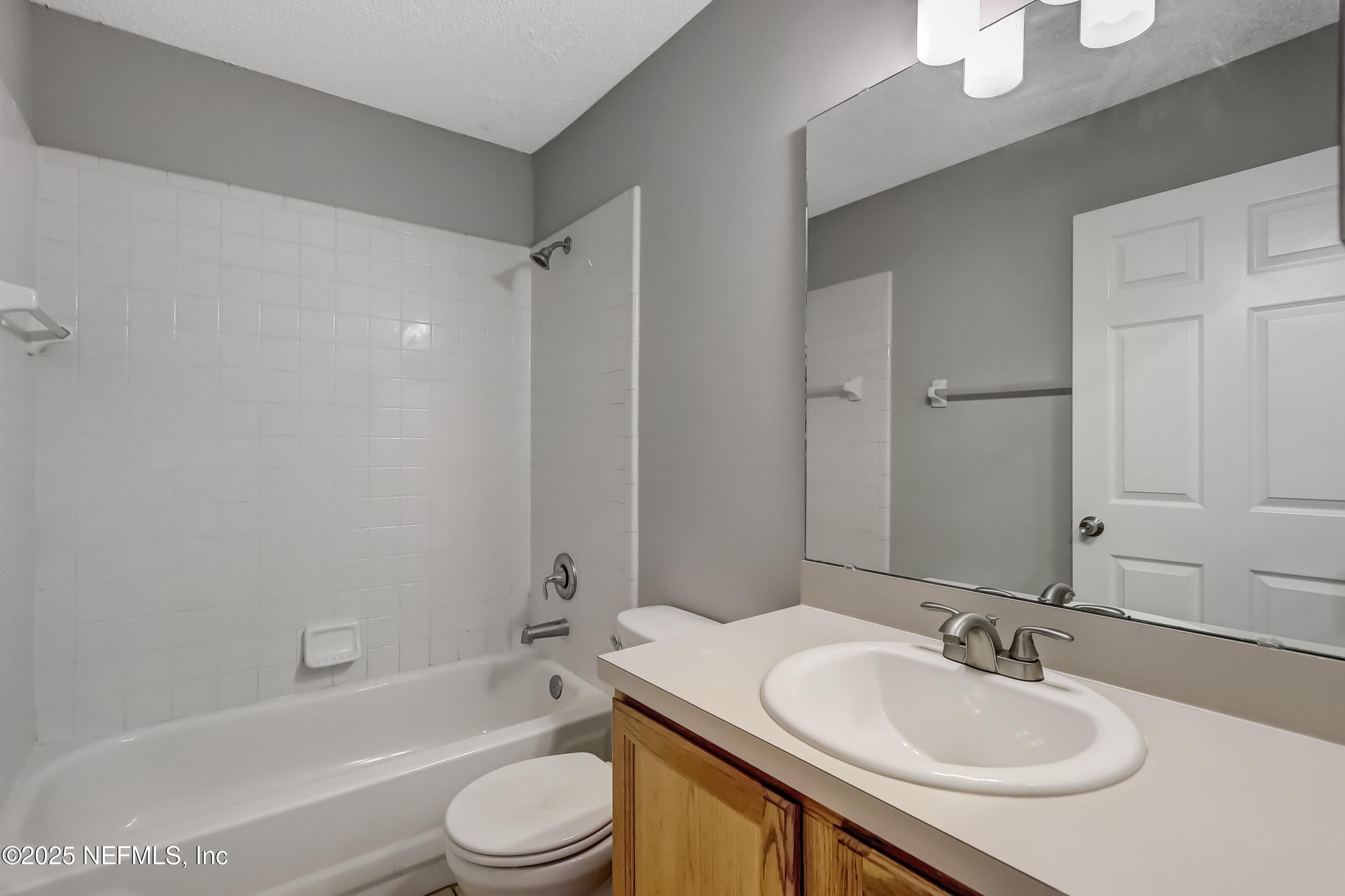 9642 Pritmore Road East Jacksonville, FL 32257 - Photo 37 of 47 a bathroom with a granite countertop sink toilet a mirror and shower