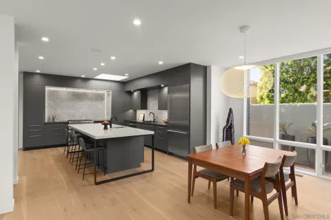 a bedroom with a large bed and a flat tv screen on dresser next to a window