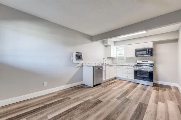 a kitchen with a refrigerator and a stove top oven