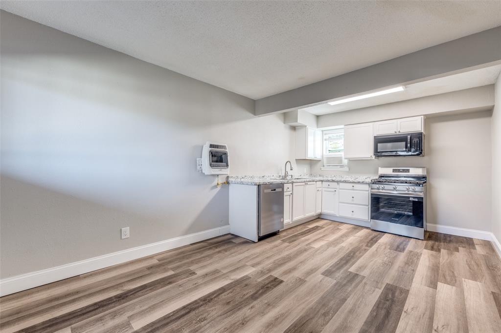 1001 West Elm Street, Unit 201 Denison, TX 75020 - Photo 1 of 12 a kitchen with a refrigerator and a stove top oven