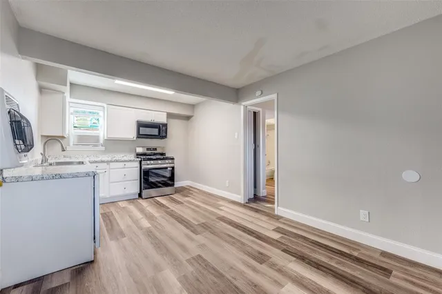 a kitchen with a refrigerator sink and cabinets