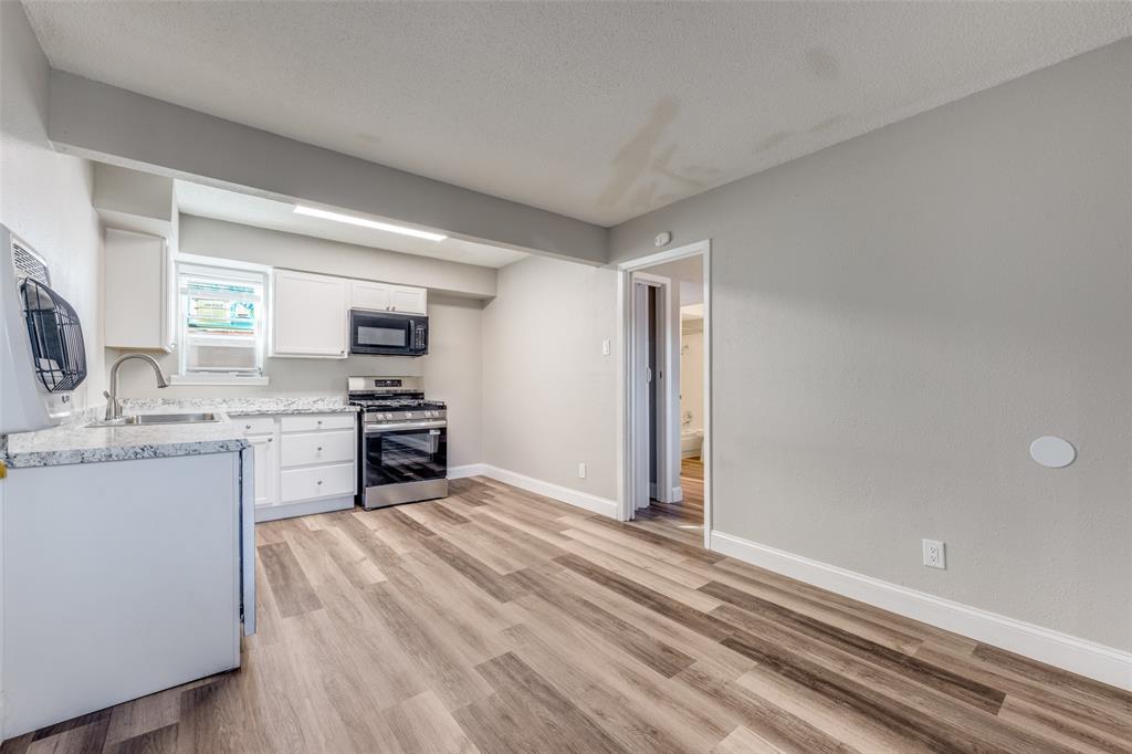 1001 West Elm Street, Unit 201 Denison, TX 75020 - Photo 2 of 12 a kitchen with a refrigerator sink and cabinets