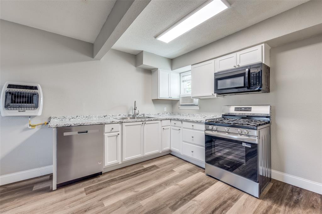 1001 West Elm Street, Unit 201 Denison, TX 75020 - Photo 3 of 12 a kitchen with stainless steel appliances granite countertop a stove top oven a sink dishwasher and a microwave oven on the wooden floor
