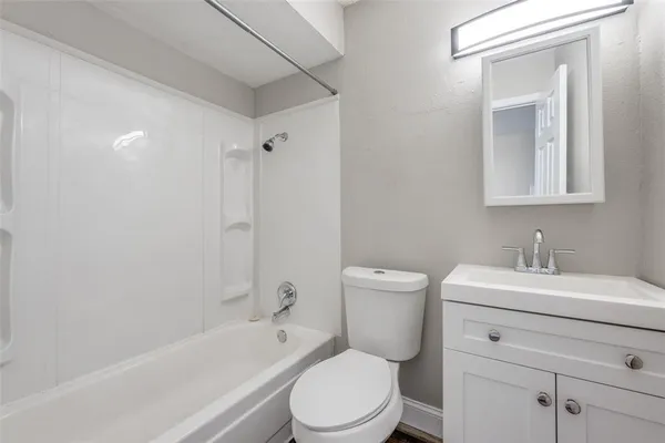 a bathroom with a sink toilet vanity and tub