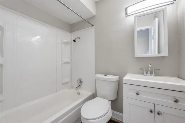 a bathroom with a sink toilet vanity and tub