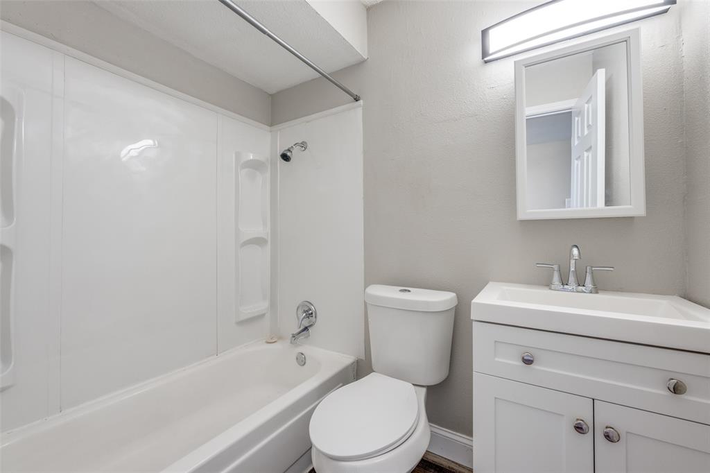 1001 West Elm Street, Unit 201 Denison, TX 75020 - Photo 8 of 12 a bathroom with a sink toilet vanity and tub