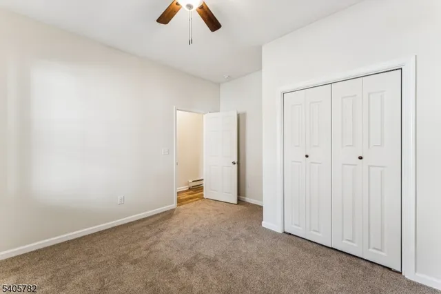 an empty room with ceiling fan and window