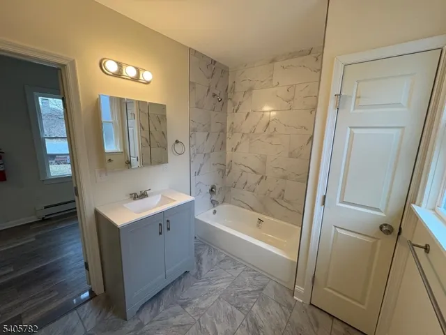 a bathroom with a tub sink and mirror