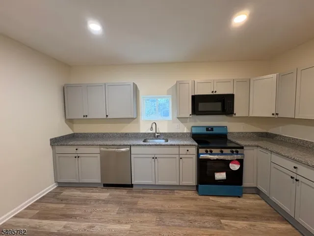 a kitchen with stainless steel appliances a sink a stove a microwave and cabinets