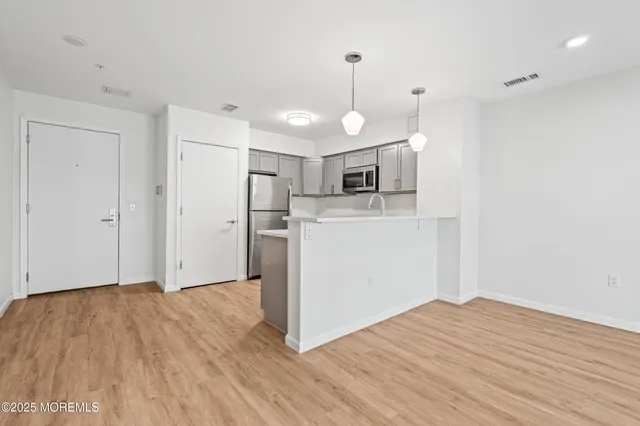 a view of a kitchen with a microwave and wooden floor