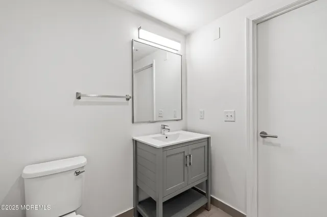 a bathroom with a sink a toilet and a mirror