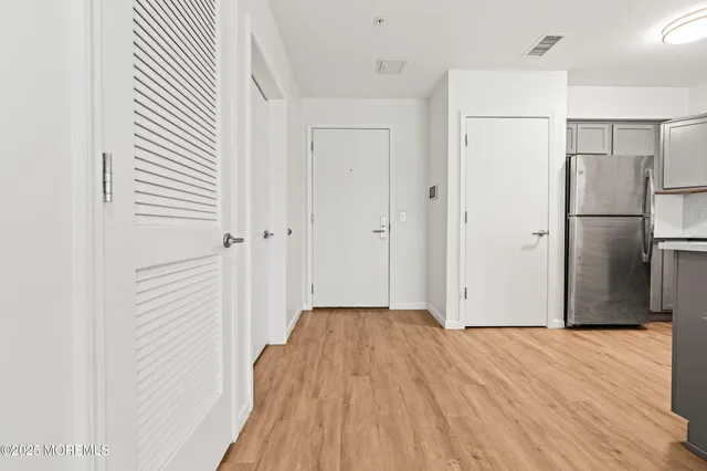 a view of a refrigerator in kitchen and wooden floor