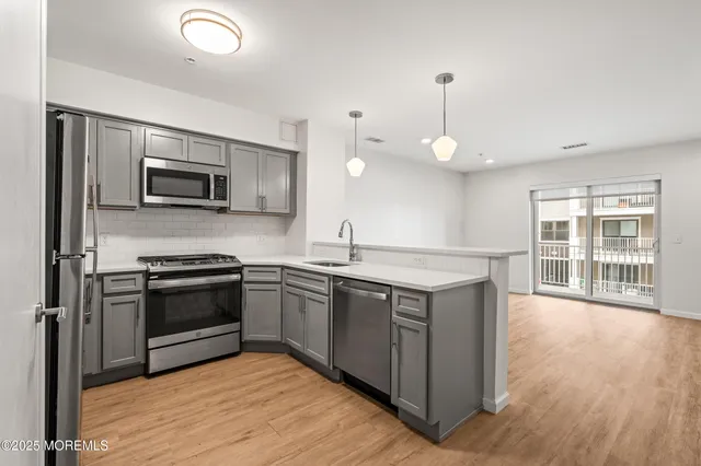 a kitchen with stainless steel appliances granite countertop a stove a sink and a microwave