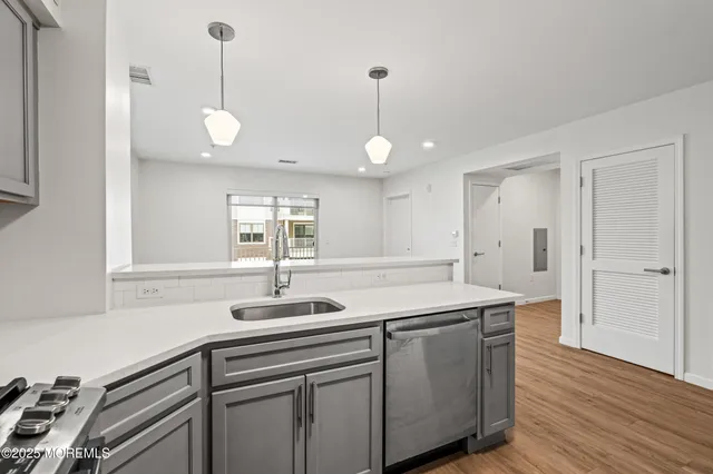a kitchen with a sink and a wooden floor