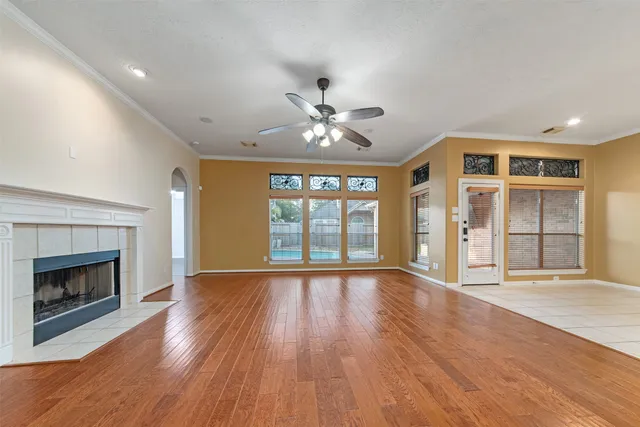 wooden floor fireplace and windows in an empty room